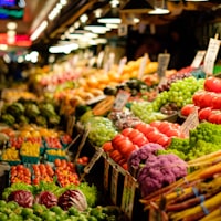 A market stall stacked with fruit and vegetables in wooden crates